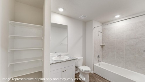 San Antonio Applewood New Construction Homes secondary bathroom with open shelving single vanity sink white cabinets and combined tub and shower