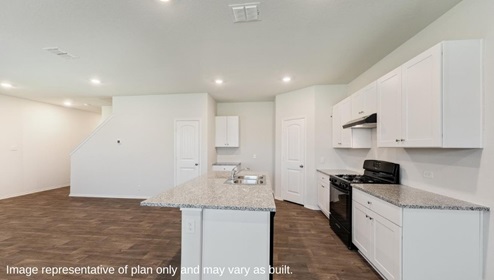 San Antonio Applewood New Construction Homes open concept kitchen with white cabinets back appliances and large kitchen island