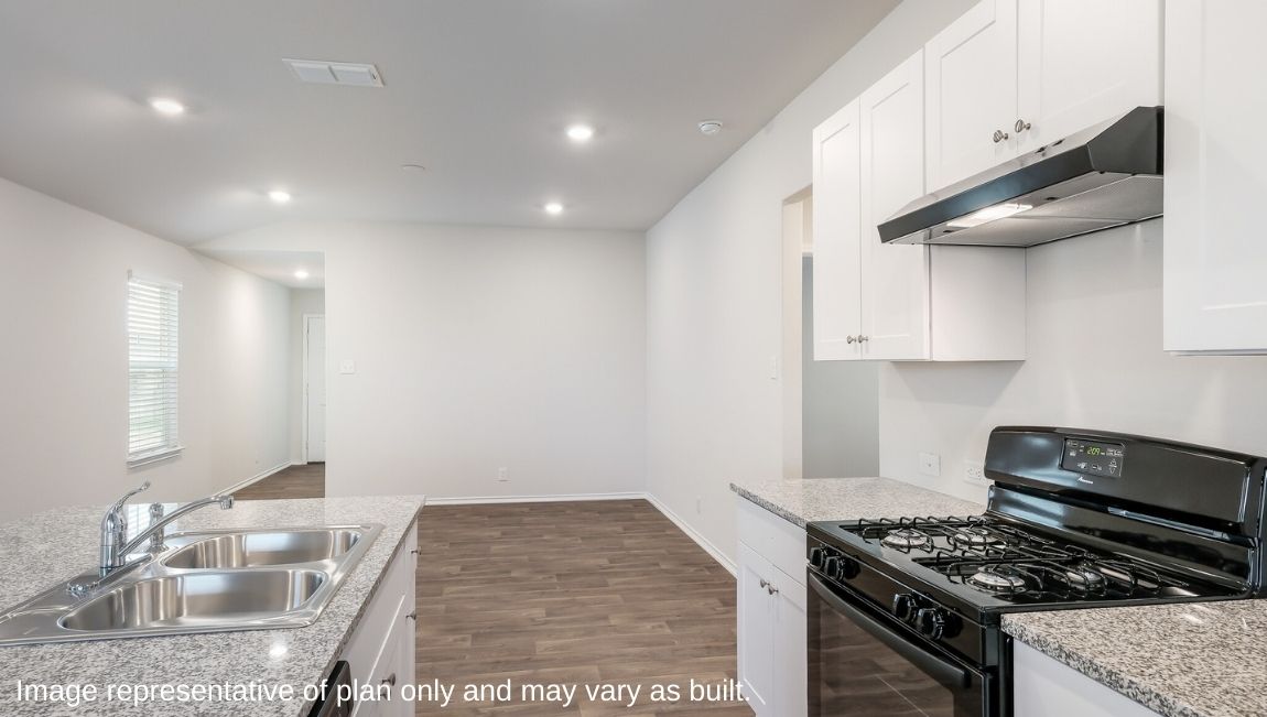 Spacious kitchen with stainless steel appliances and hard surface flooring.