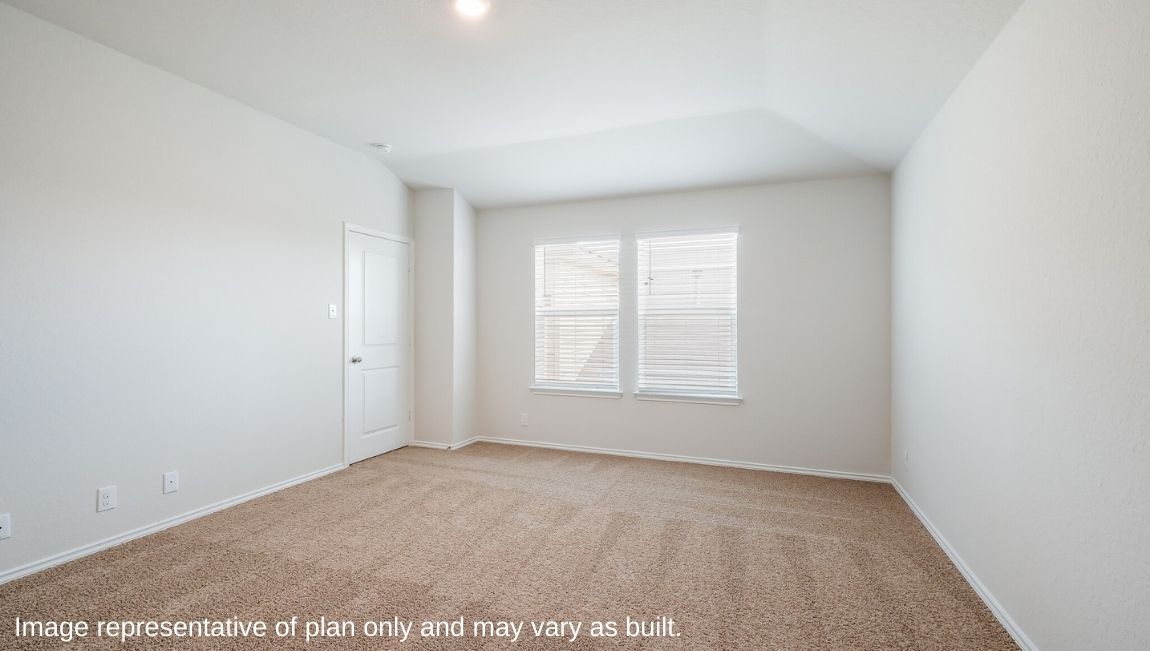 Spacious primary bedroom with windows and walk-in closet.