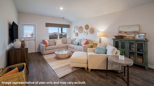 Open-concept family room with hard surface flooring, large windows, and door leading to back patio