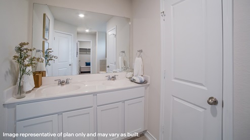 Primary ensuite bathroom with dual vanity sinks and separate water closet