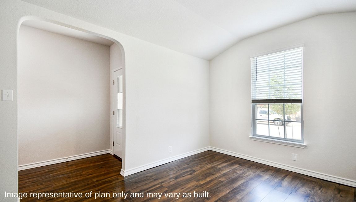 Spacious dining area with hard surface flooring and large window.