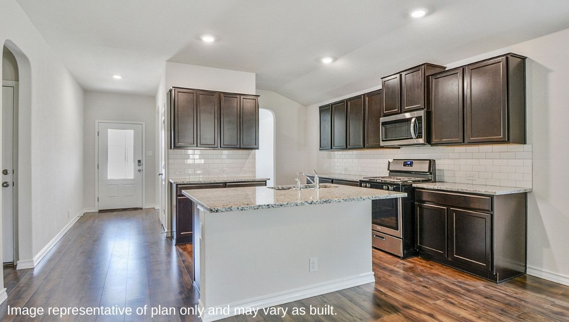 Spacious kitchen with stainless steel appliances and deep kitchen island facing the living room.