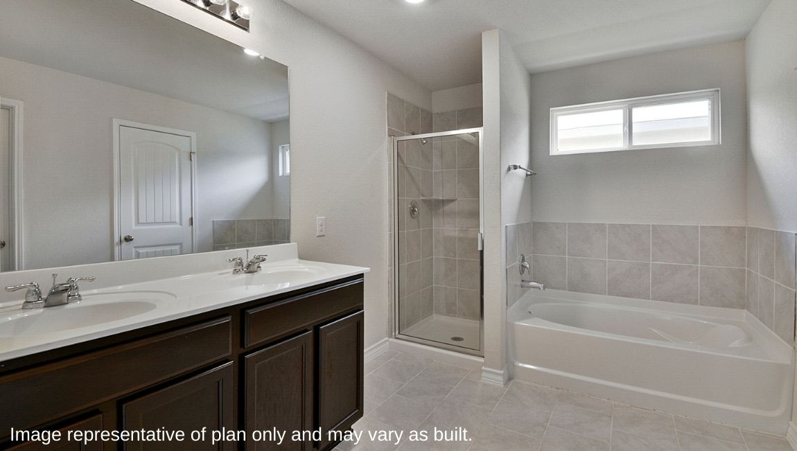 Spacious primary bathroom with double vanity sink, separate tub and walk-in shower.