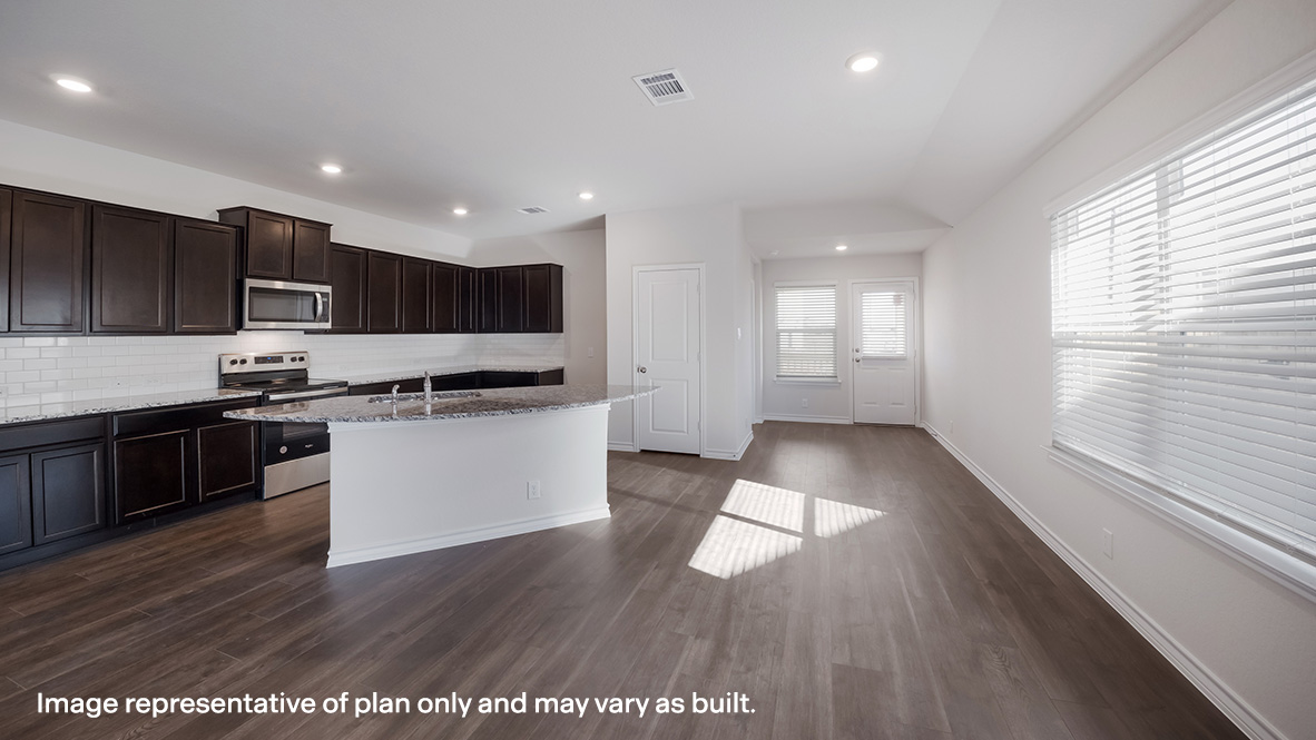Open-concept kitchen and dining area with windows and patio door.