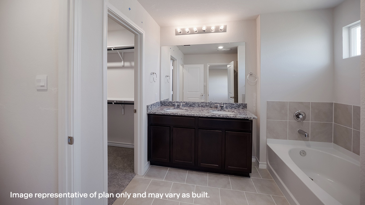 Spacious primary bathroom complete with separate tub and shower and dual vanities.