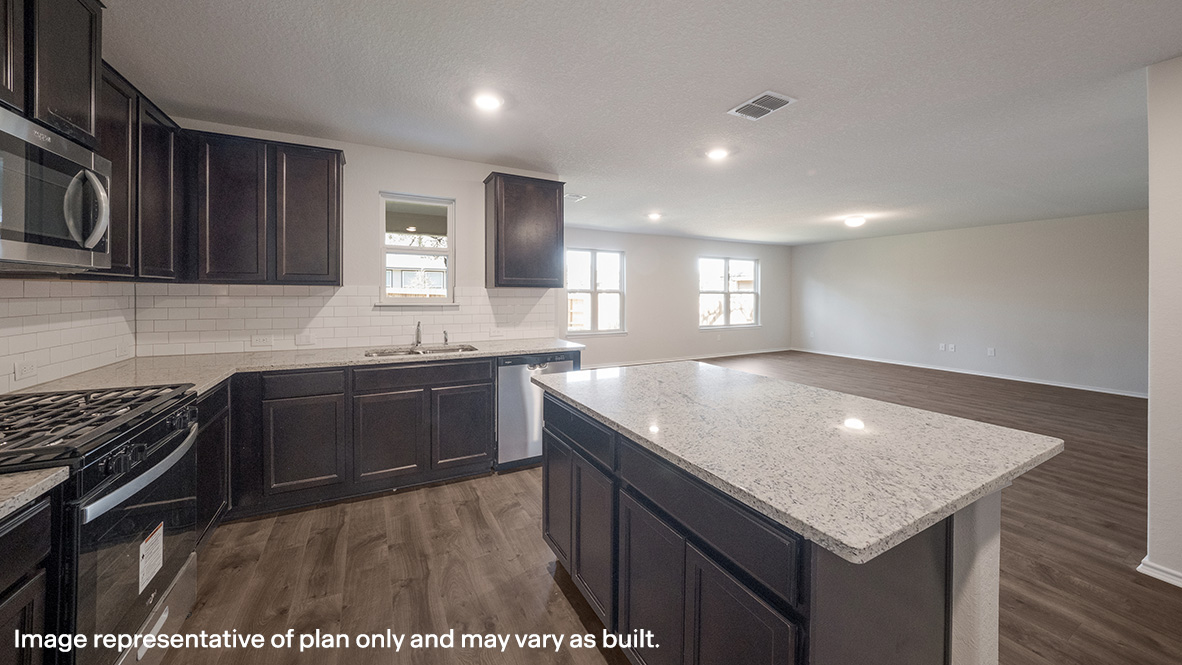 Spacious kitchen with classic white subway tile backsplash, sink facing large window and spacious corner pantry.