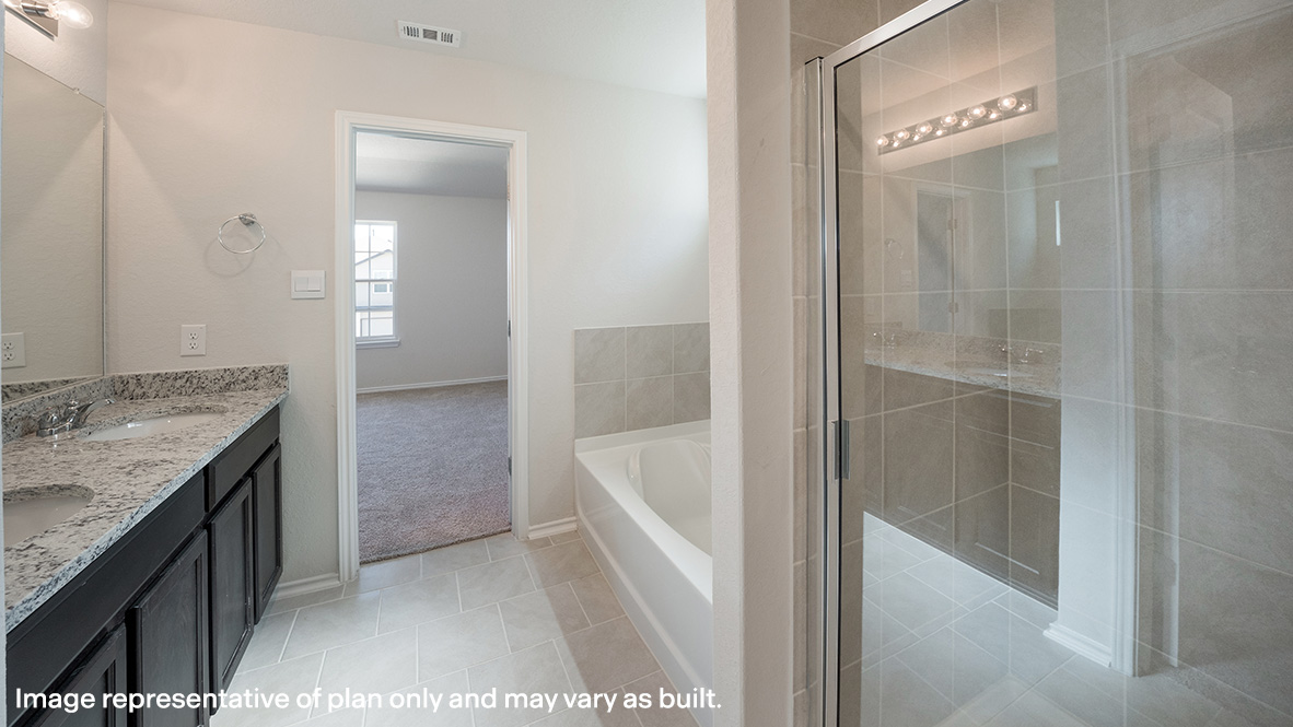Primary bathroom with separate tub and shower and double vanity sinks.
