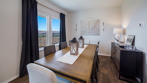 Open-concept dining area with hard surface flooring and large windows.