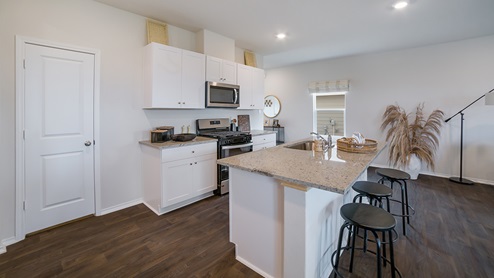 Kitchen with shaker style cabinets, granite countertops and stainless steel appliances.