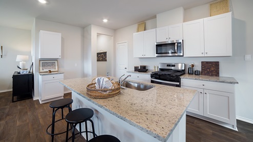 Kitchen overlooking dining and living areas with windows providing plenty of natural light.