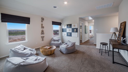 Spacious, open-concept loft at top of staircase with quality carpet and windows.
