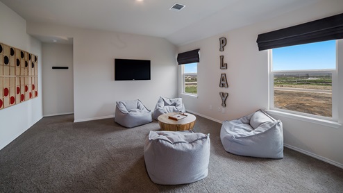 Spacious, open-concept loft at top of staircase with quality carpet and windows.