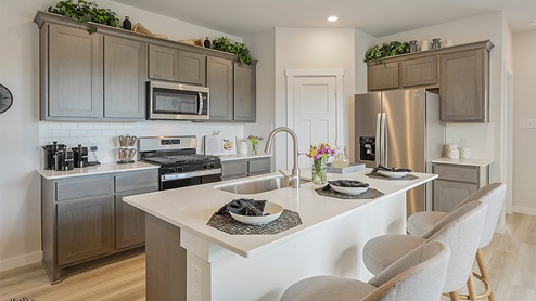 Midtown Model kitchen with stainless steel appliance and black and white decor.