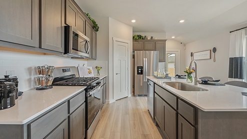 Midtown Model kitchen with gas range and corner pantry.