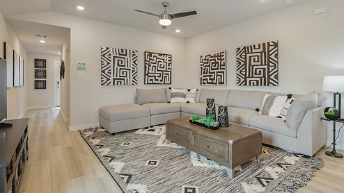 Midtown Model living room with gray couch and geometric artwork.