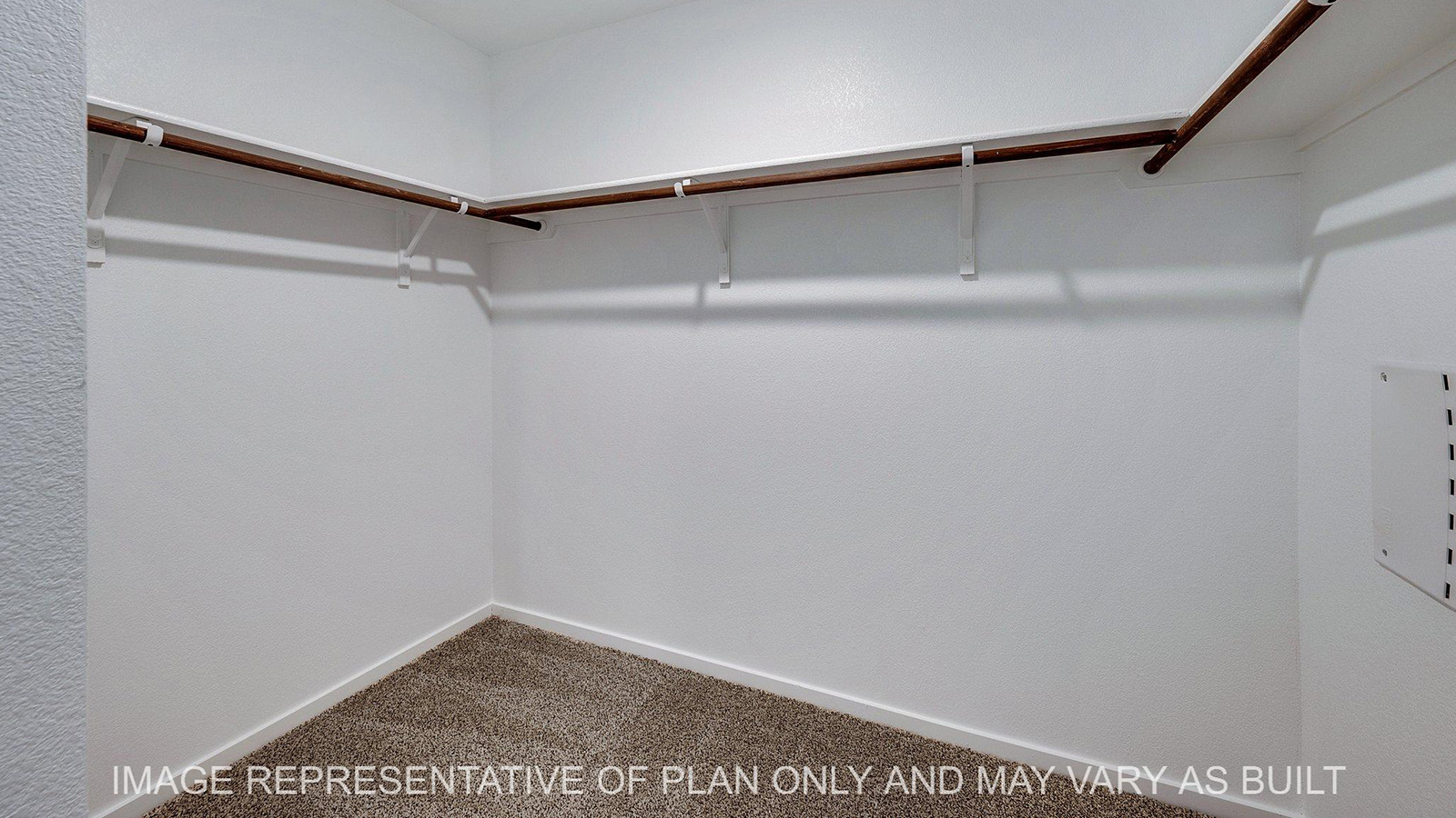 Brooke primary walk-in closet with carpeted flooring.