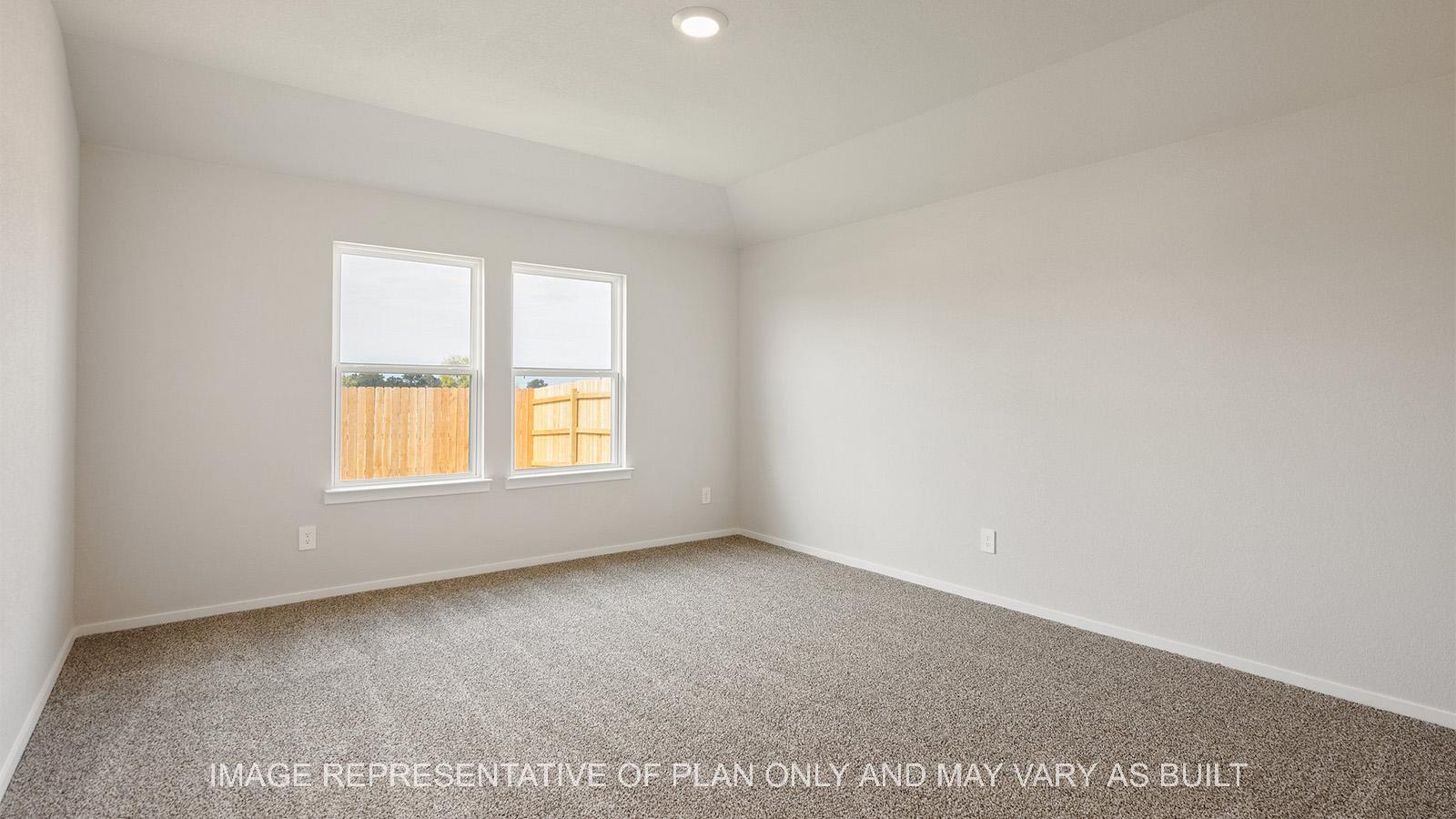 Caroline primary bedroom with carpeted flooring and two windows.