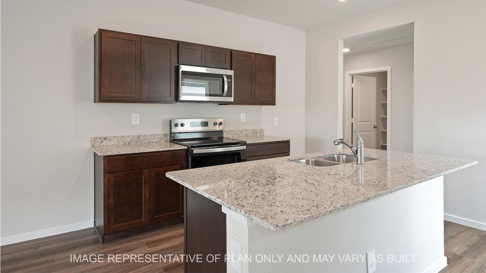 Caroline kitchen with dark stained cabinetry, granite countertops, and vinyl plank flooring.