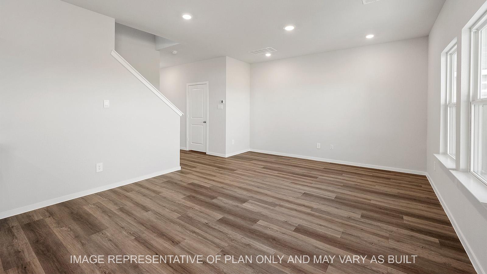 Emma open-concept living room with vinyl plank flooring and windows.