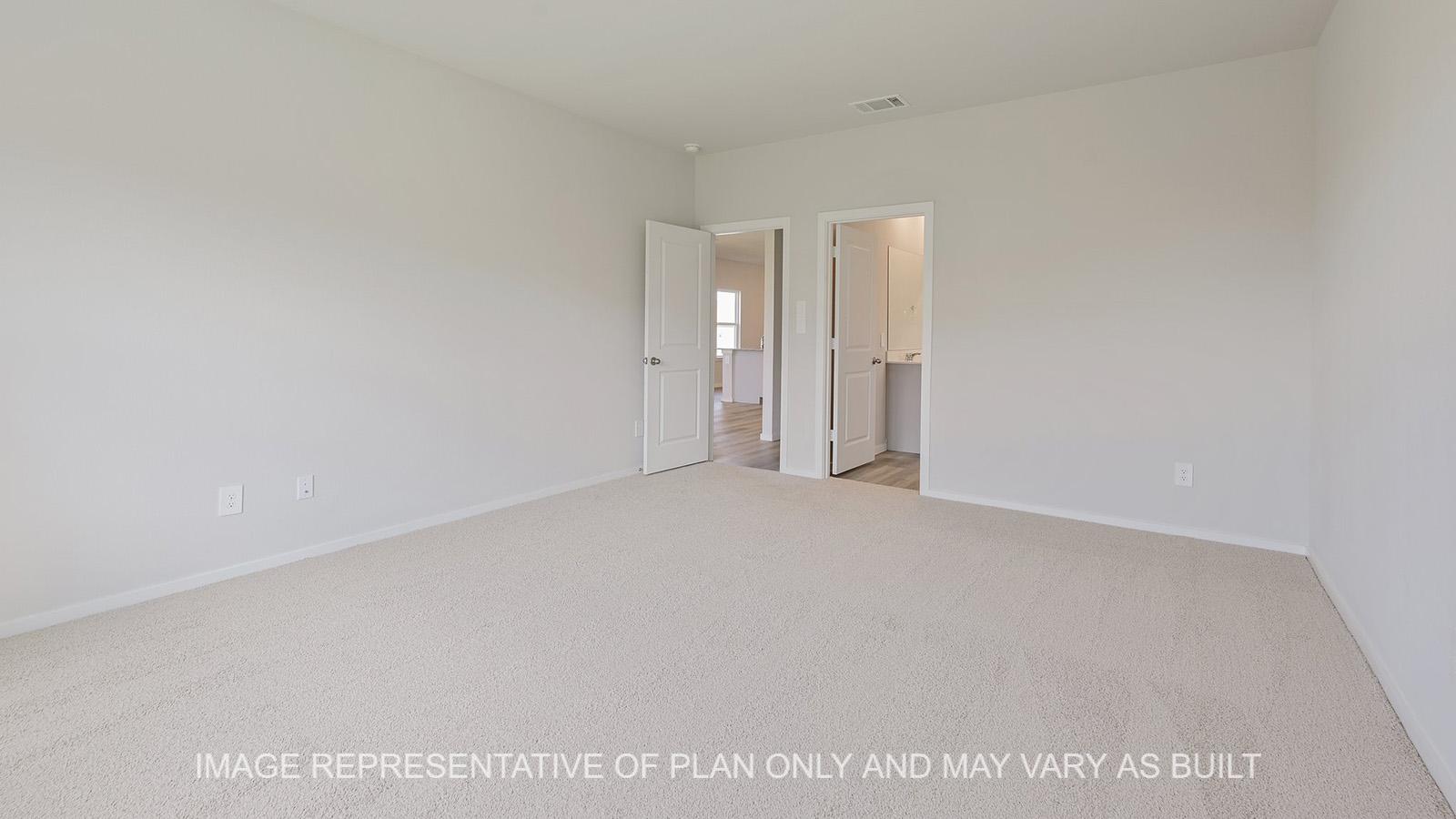 Jasmine primary bedroom with carpeted flooring and bathroom access.