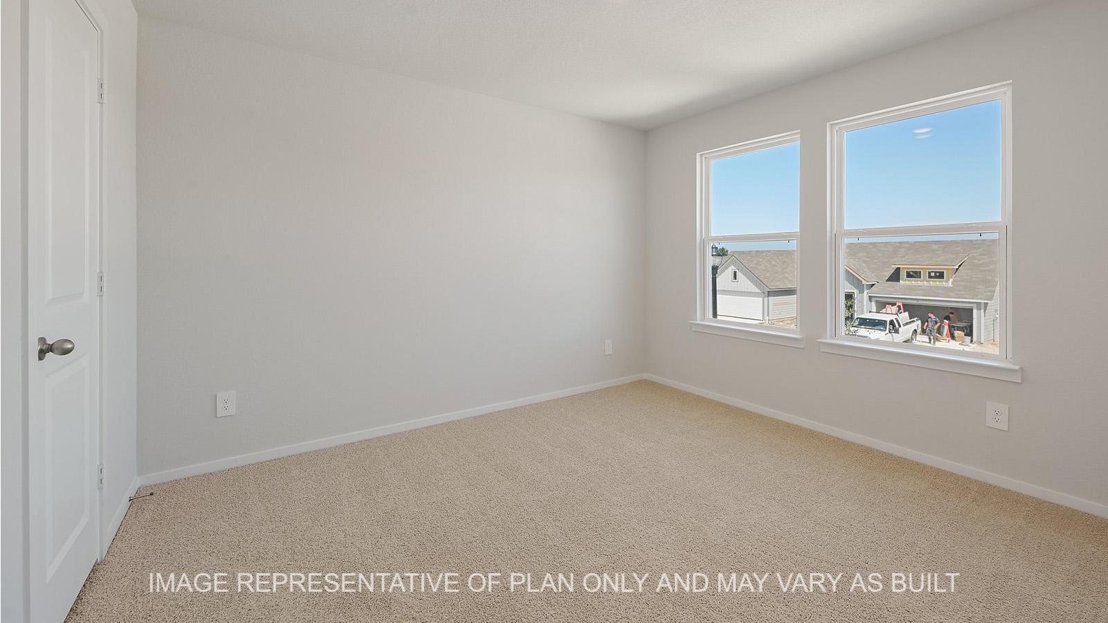 Jasmine secondary bedroom with windows and carpeted flooring.