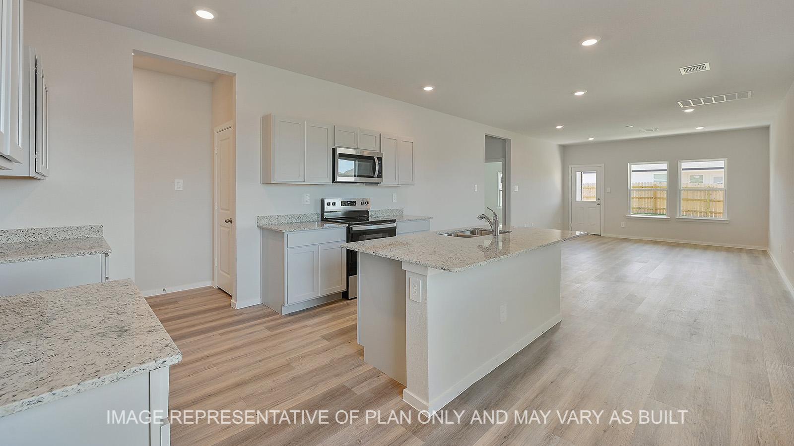 Jasmine kitchen with granite countertops, white cabinetry, and vinyl plank flooring.