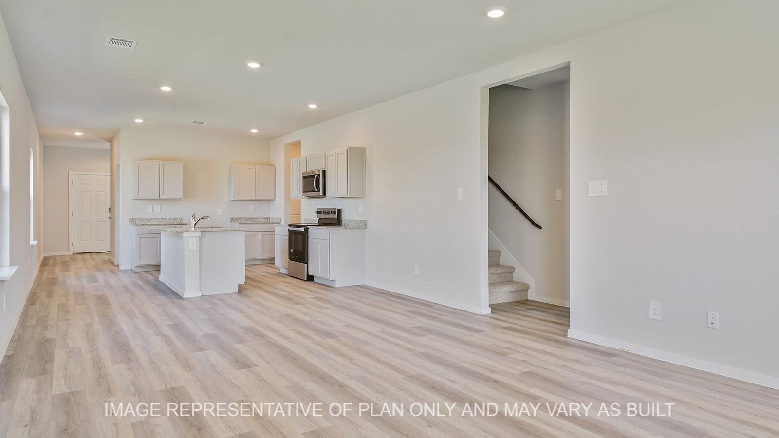Jasmine open-concept living room with vinyl plank flooring and view to kitchen.