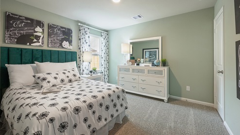 Pleasant Hill Model Home secondary bedroom with carpeted flooring and girls furniture.