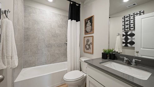 Pleasant Hill Model Home secondary bathroom with shower/tub combo with ceramic tile surround.