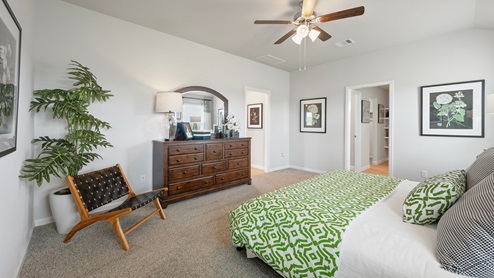 Pleasant Hill Model Home primary bedroom with carpeted flooring and access to living room.
