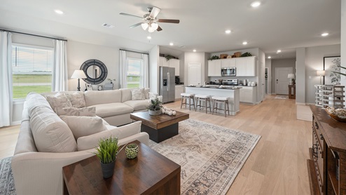 Pleasant Hill Model Home living room with white sectional and view to kitchen.