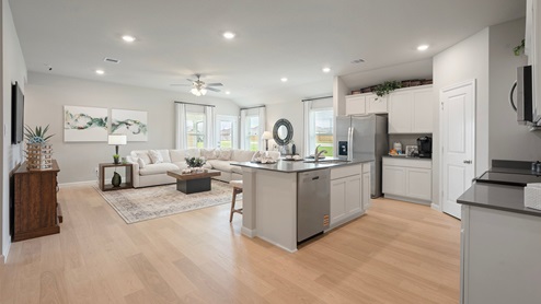 Pleasant Hill Model Home kitchen and living area with quartz countertops and vinyl plank flooring.