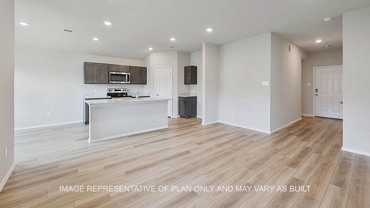 Ashburn open-concept living room with vinyl plank flooring and view to kitchen.