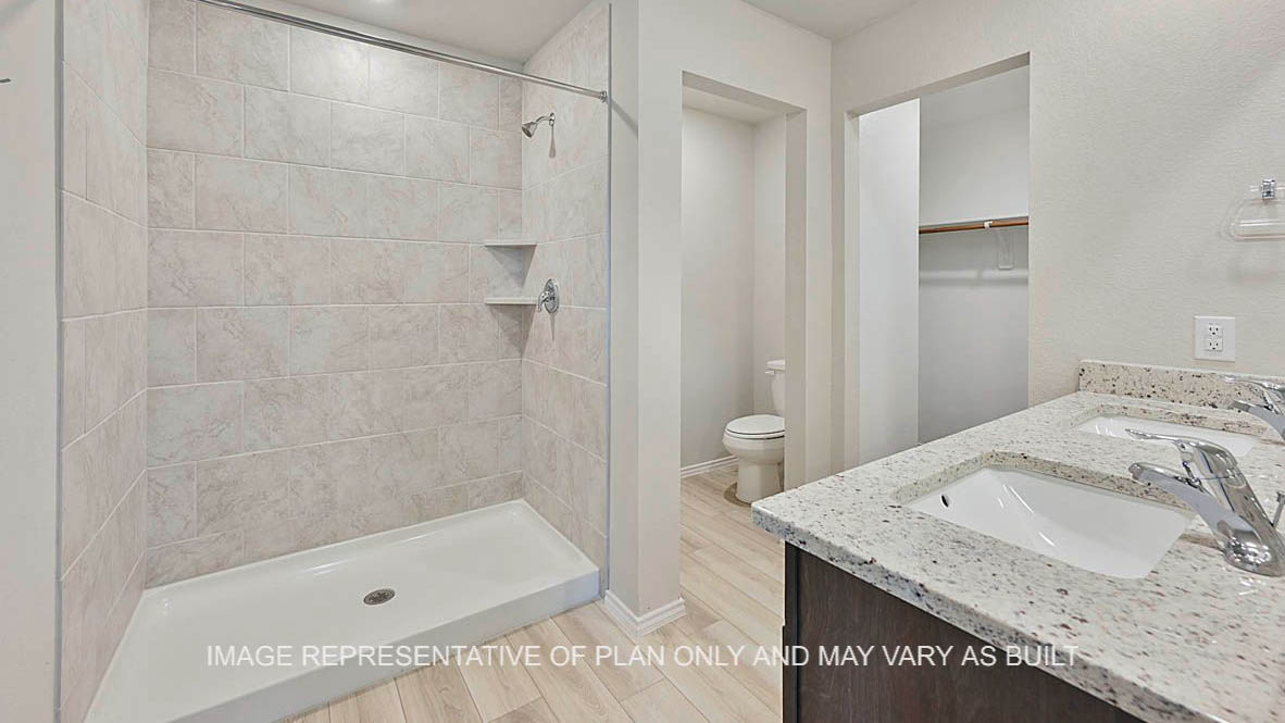 Ashburn primary bathroom with dark stained cabinetry, vinyl plank flooring, granite countertops and ceramic tile shower surround.