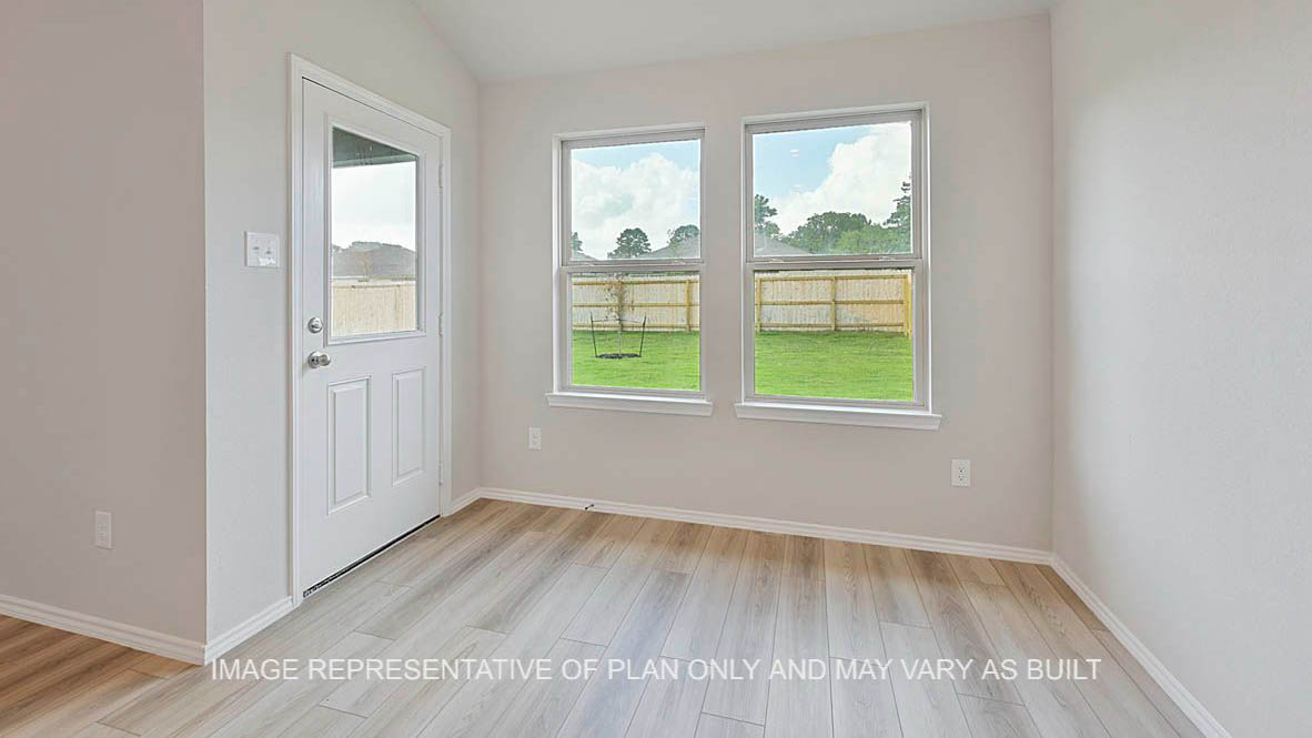 Ashburn open-concept dining area with vinyl planl flooring, windows to backyard, and back door.