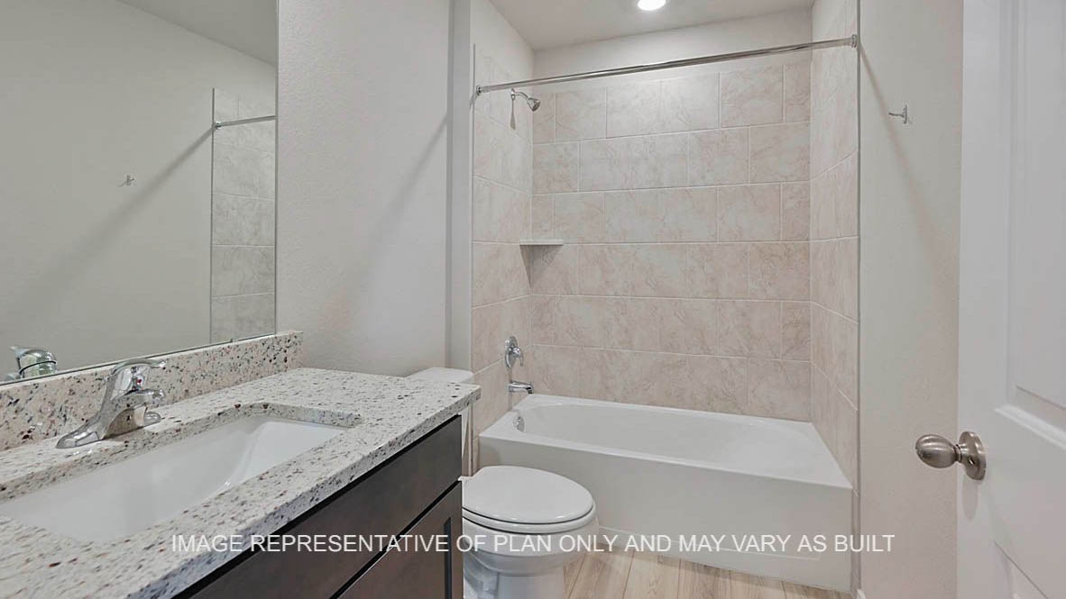 Ashburn secondary bathroom with dark stained cabinetry, granite countertops, vinyl plank flooring, and ceramic tile shower bath surround.
