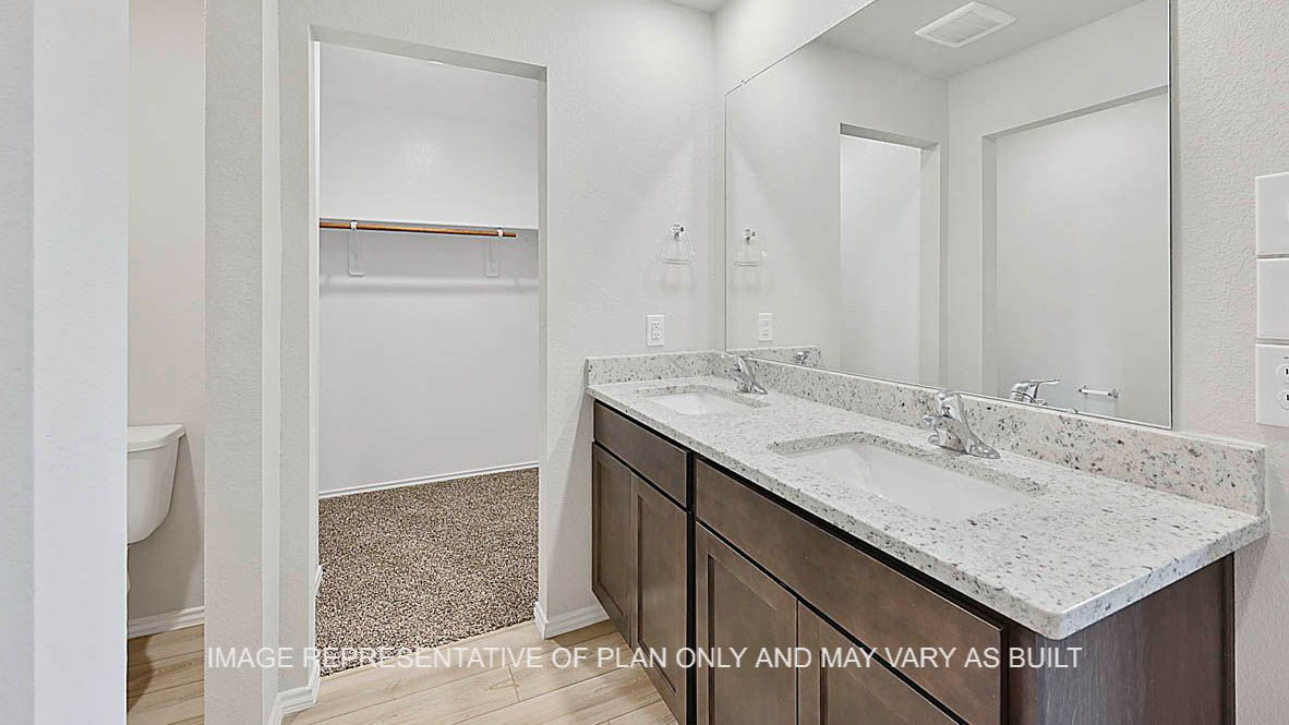 Ashburn primary bathroom with dark stained cabinetry, vinyl plank flooring, granite countertops and ceramic tile shower surround.