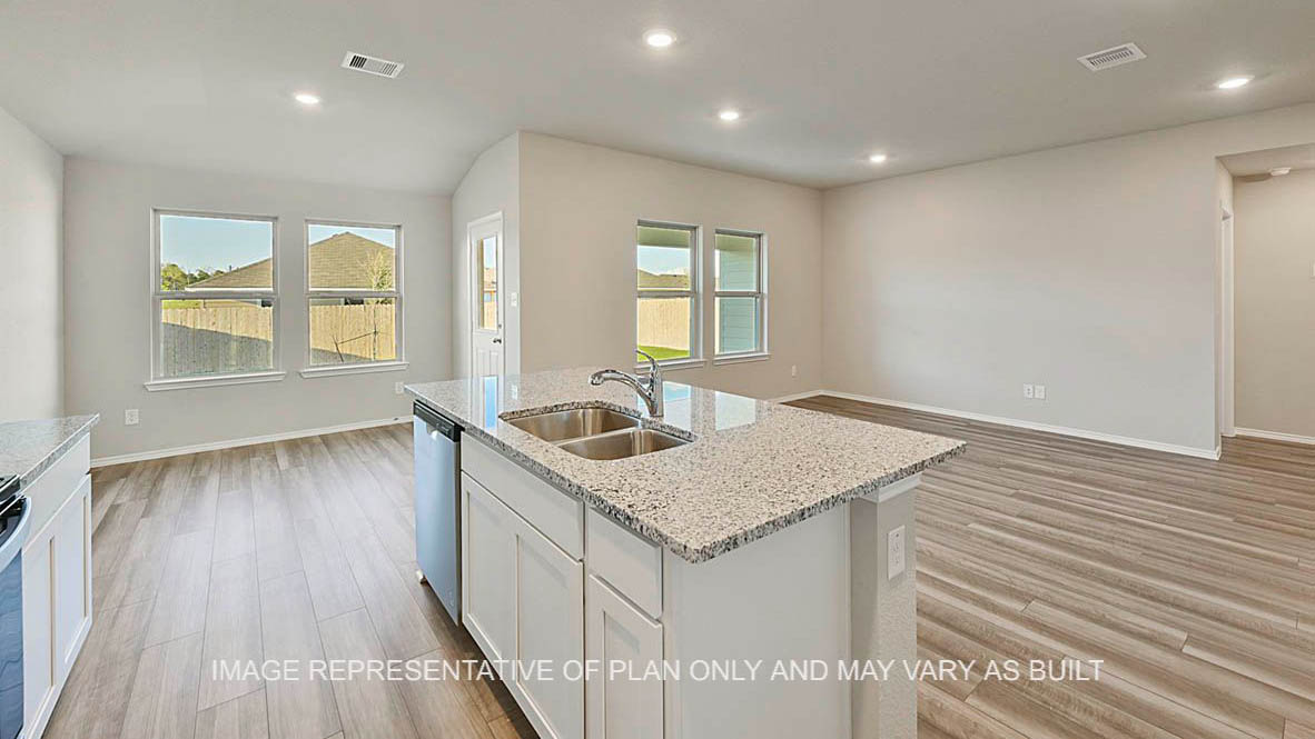 Bellvue kitchen with granite countertops, white cabinetry, vinyl plank flooring and view to open-concept living and dining areas.