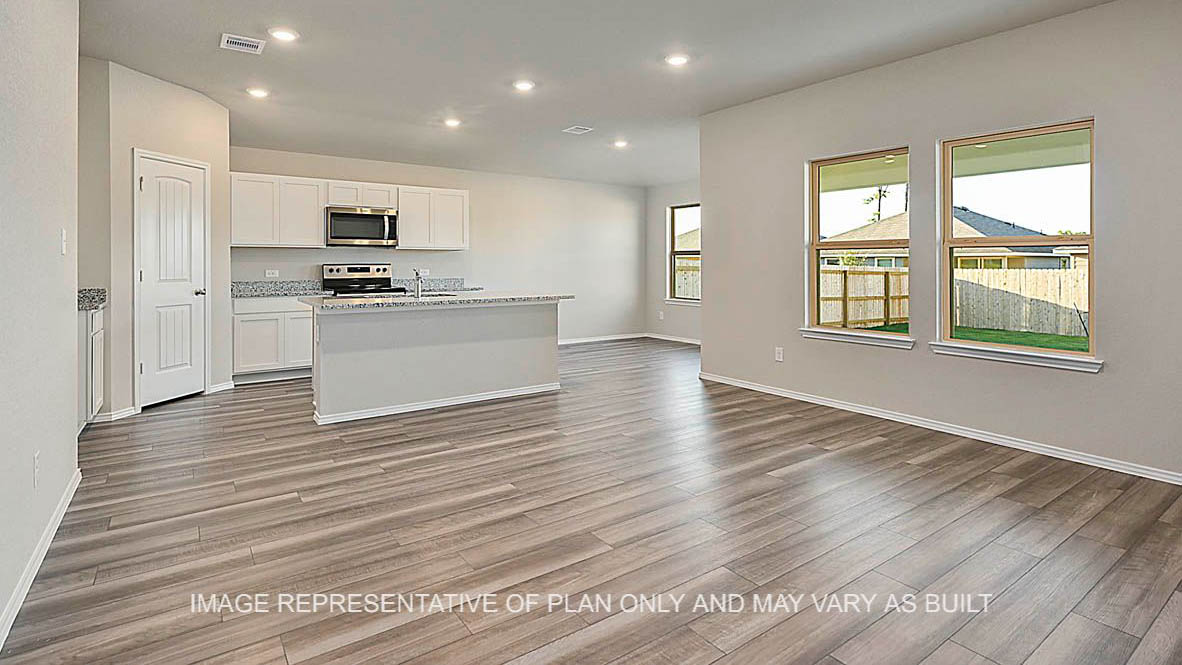 Bellvue open-concept living room with cinyl plank flooring, windows and view to kitchen.