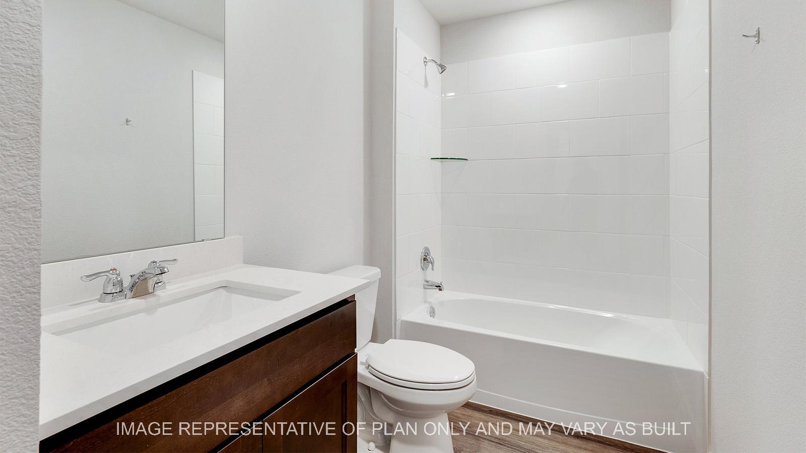 Camden secondary bathroom with quartz vanity and ceramic tile shower/tub surround.