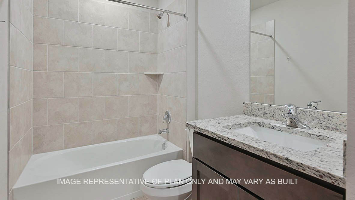Fargo secondary bathroom with dark stained cabinetry, granite countertops, ceramic tile shower bath surround and vinyl plank flooring.