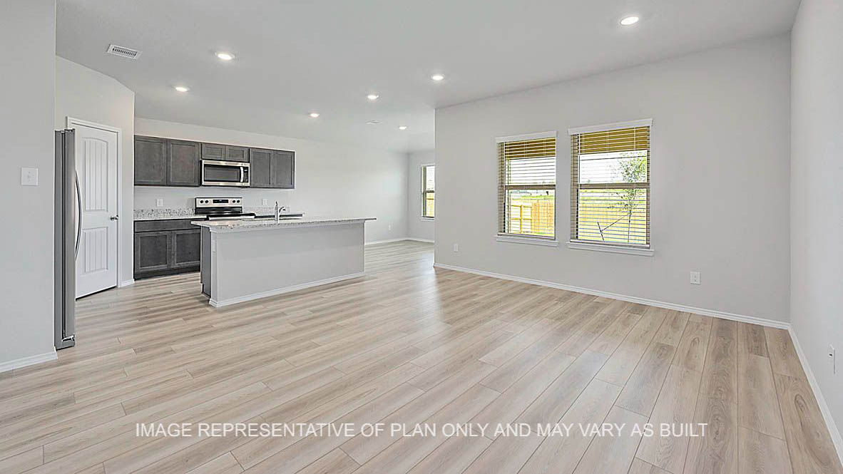 Fargo open-concept living room with windows, view to kitchen and breakfast nook, and vinyl plank flooring.