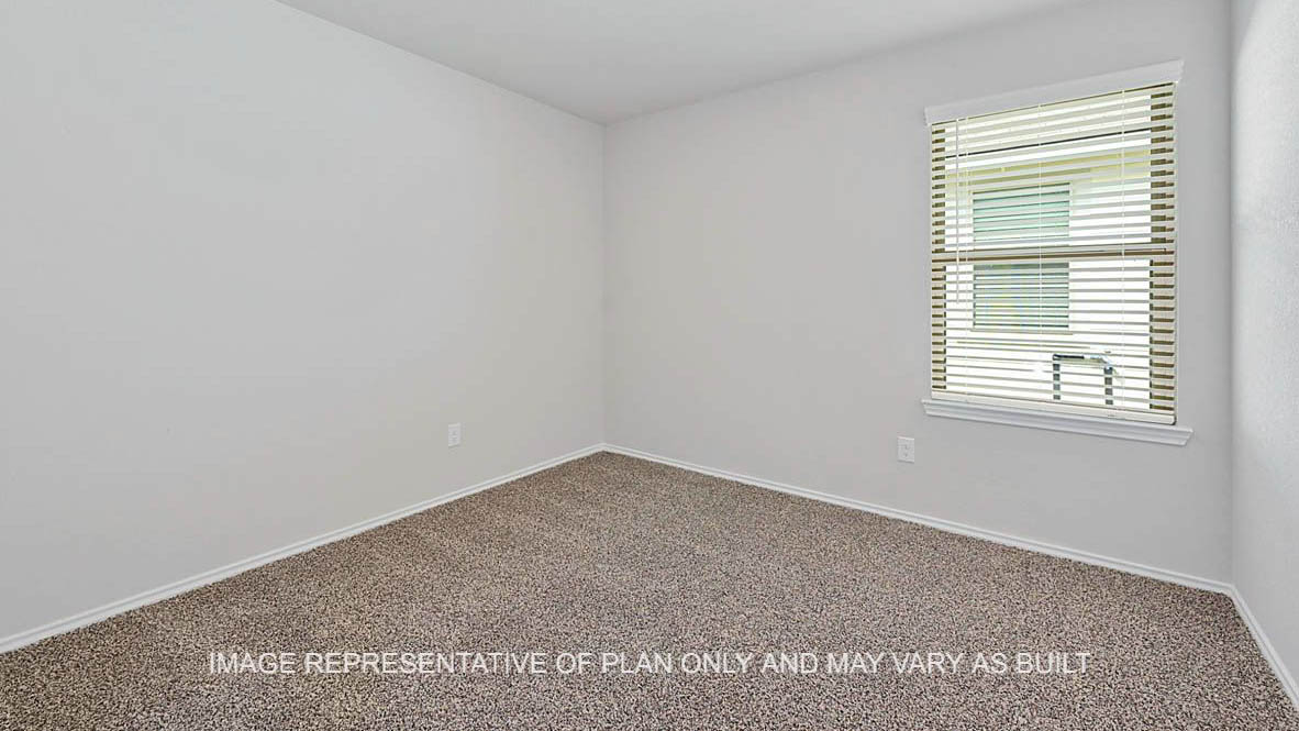 Fargo secondary bedroom with window and carpeted flooring.