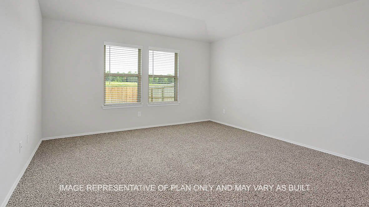 Fargo primary bedroom with windows and carpeted flooring.