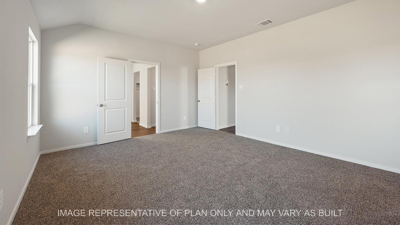Lakeway primary bedroom with carpeted flooring and windows.
