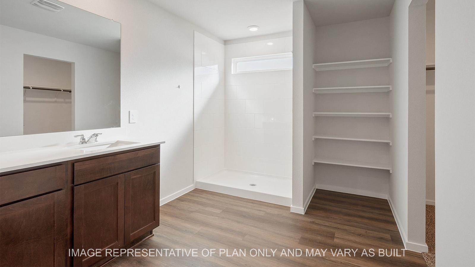 Lakeway primary bathroom with vinyl plank flooring, built-in shelving, and quarts vanity countertop.