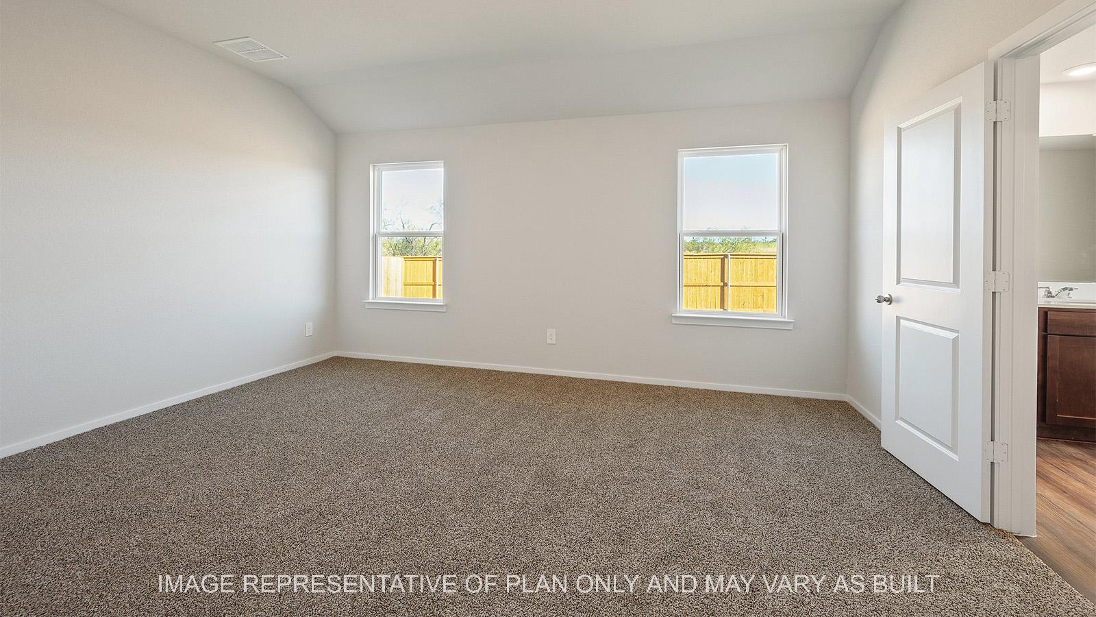 Lakeway primary bedroom with carpeted flooring and windows.