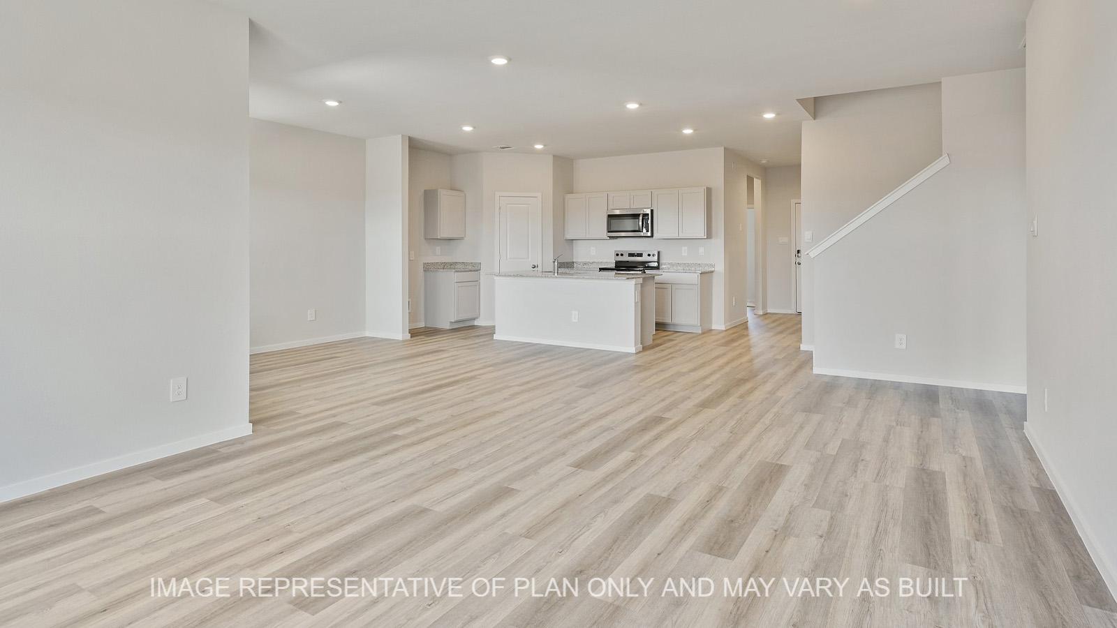 Midland open-concept living room with vinyl plank flooring and view to kitchen.
